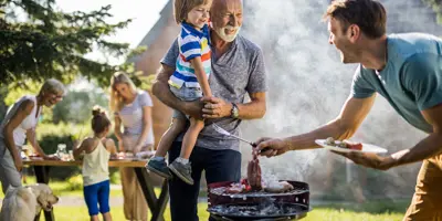 Un homme prépare un barbecue dans le jardin